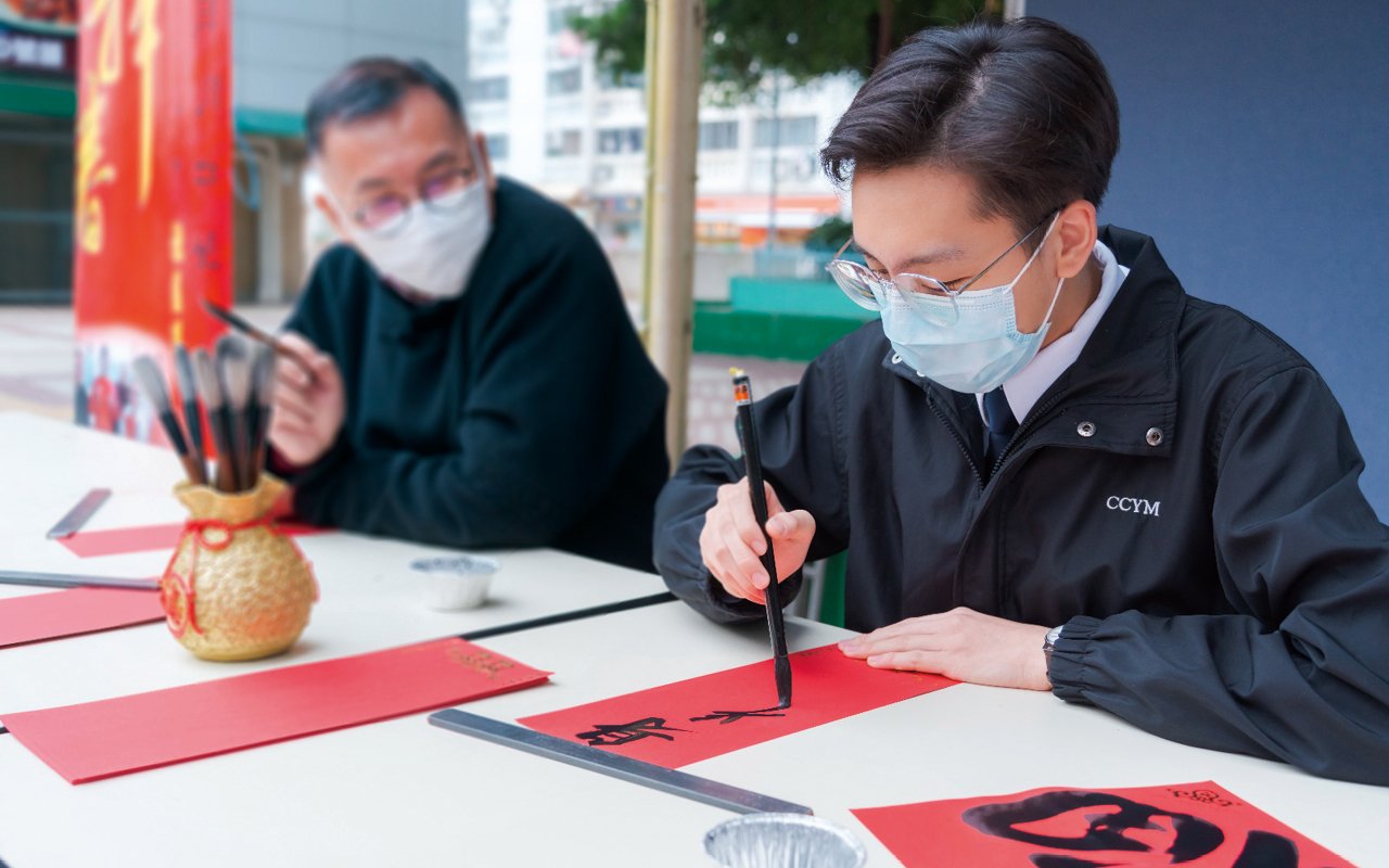 跟校長一樣熱愛書法，而且是多項比賽得獎者的李兆豐同學在社區送贈揮春。