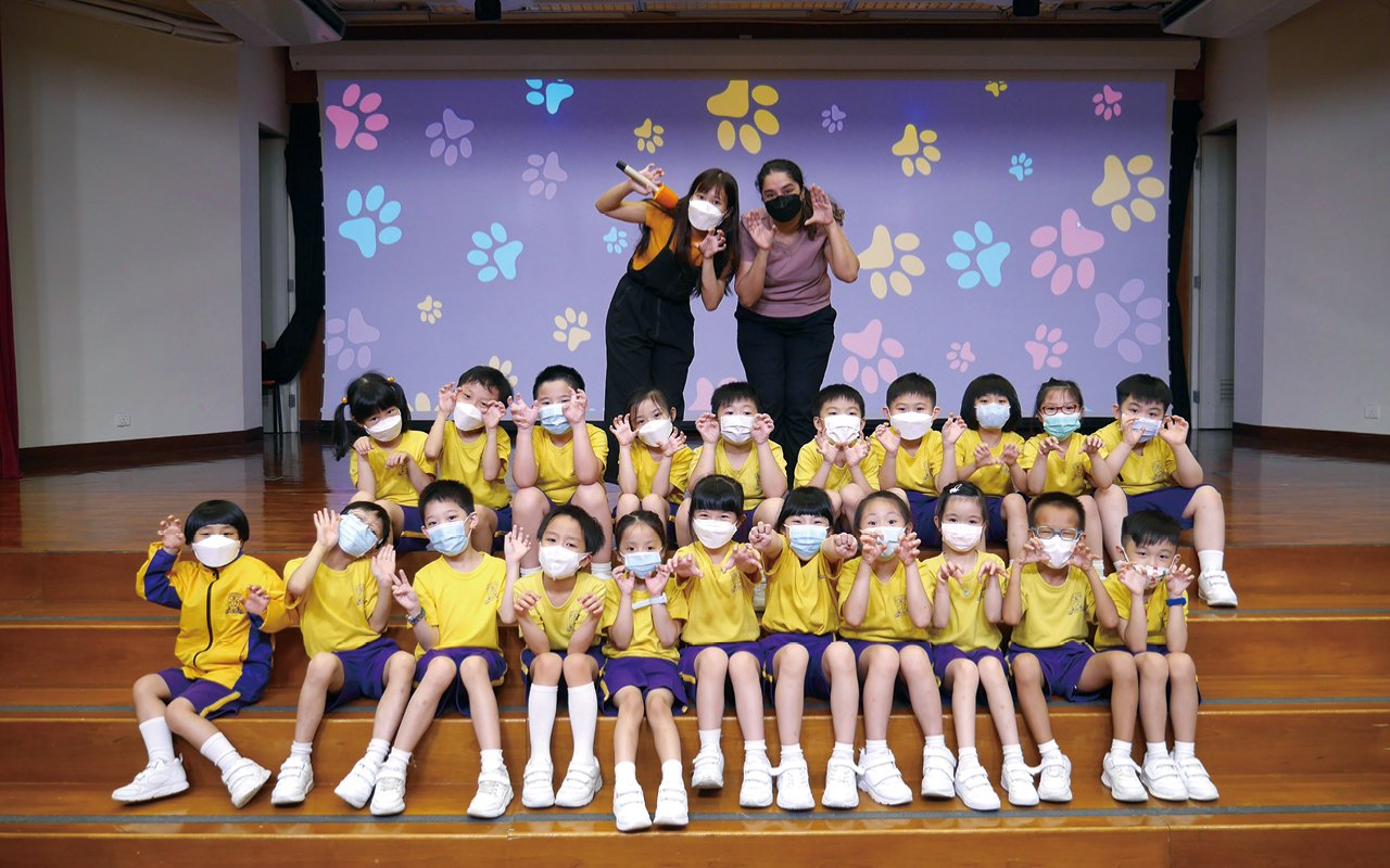 在英語戲劇課中，3名外聘外籍老師和本地老師進行協作教學，合力教授和製作英語音樂劇，讓學生以唱遊形式學習英語，藉此增加小一學生運用英語的機會和增強他們運用英語的信心。